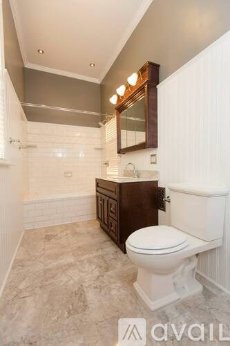 A bathroom with a toilet, sink, and mirror.