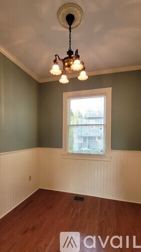 A room with a window and a chandelier.