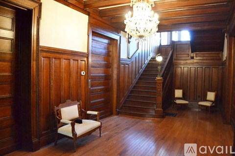 A wooden room with a staircase and a chandelier.