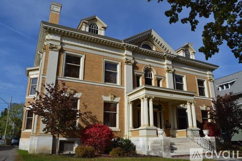 A large, two-story house with a red flower in front.