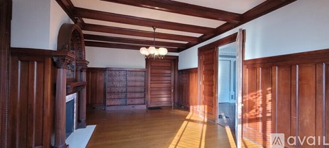 A room with wooden walls and ceiling with a chandelier hanging from the ceiling.