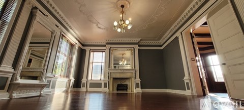 A large room with a fireplace and a chandelier.