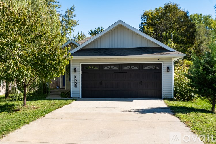 A two-car garage with a white exterior and a black roof.