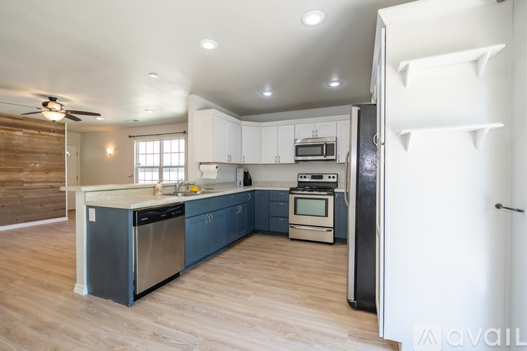 A kitchen with a white fridge and wooden walls.
