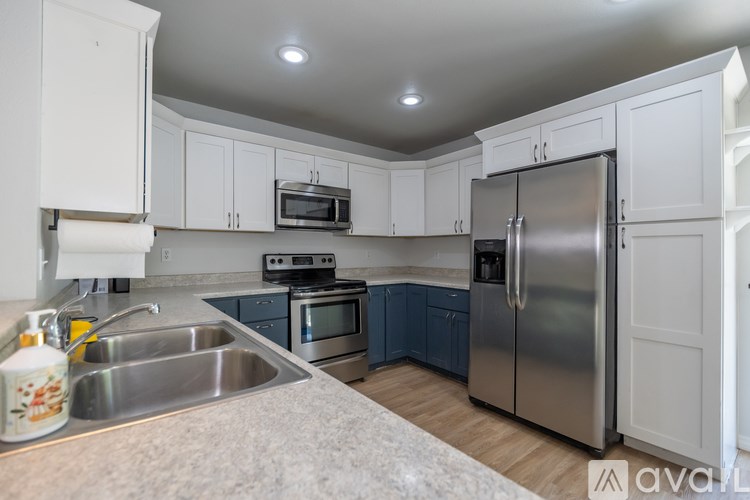 A kitchen with white cabinets and a stainless steel refrigerator.