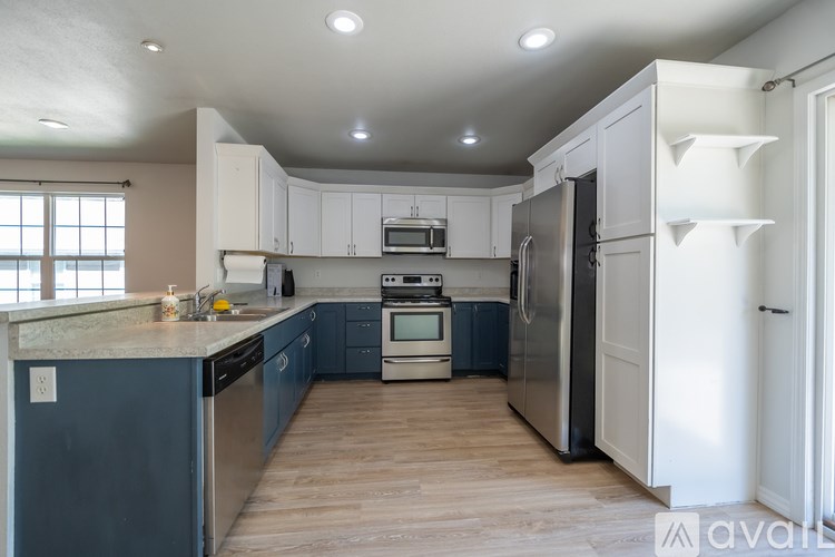 A kitchen with white cabinets and a dark blue counter.