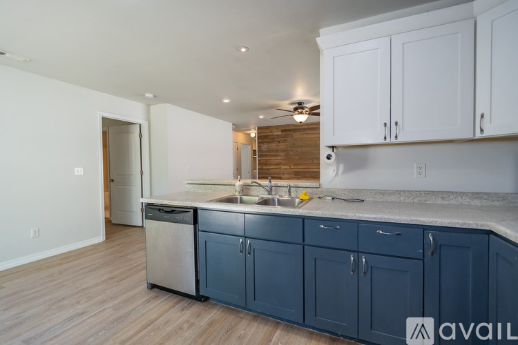A kitchen with blue cabinets and a wooden floor.