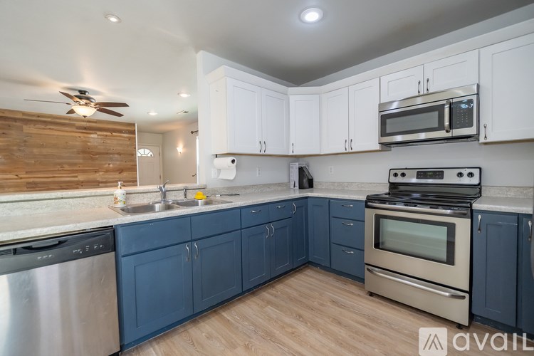 A kitchen with blue cabinets and stainless steel appliances.