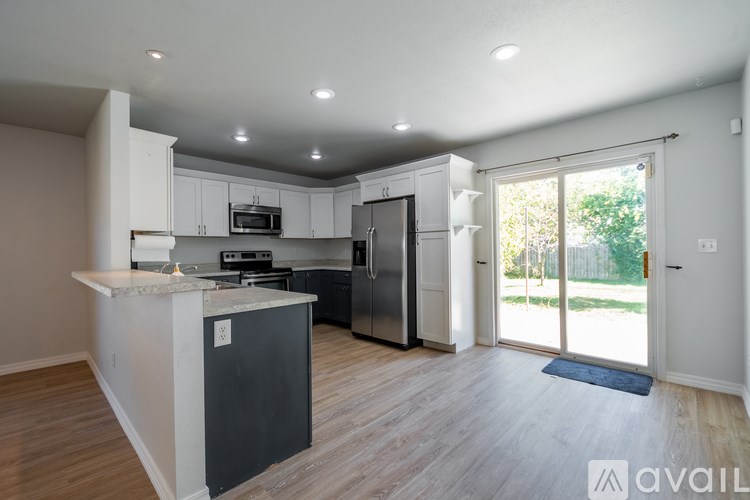 A kitchen with a refrigerator, microwave, and oven.