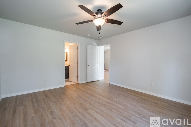 A room with a ceiling fan and wooden flooring.