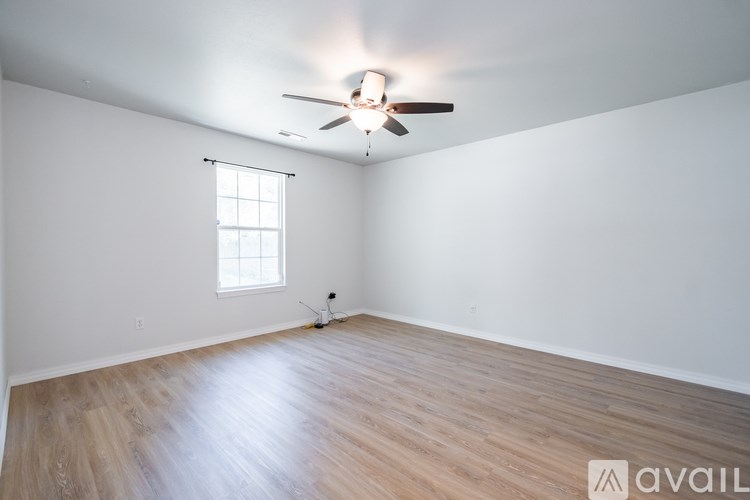 A room with a ceiling fan and a window.