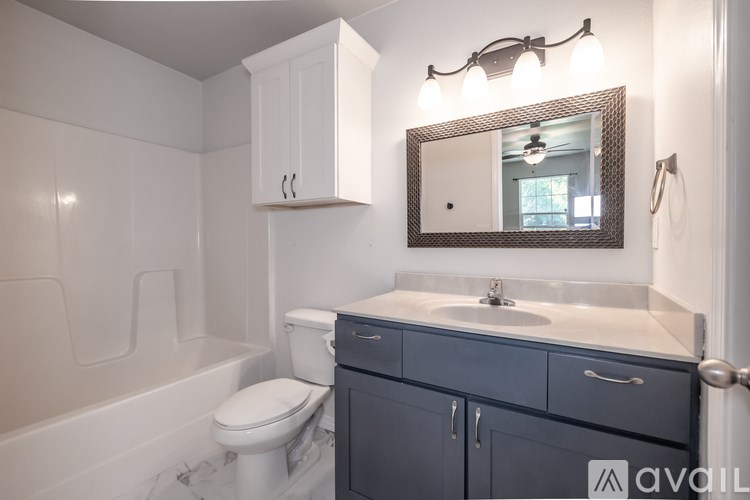 A bathroom with a white toilet and a white bathtub.