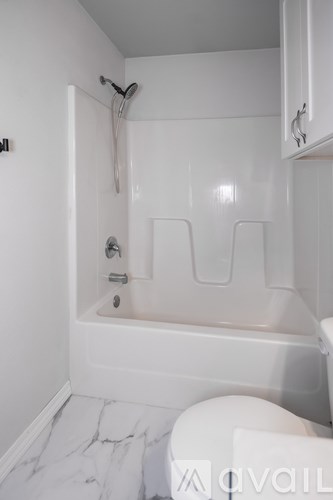 A white bathroom with a tub and toilet.