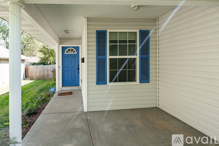 A blue door is on the left side of a white house.