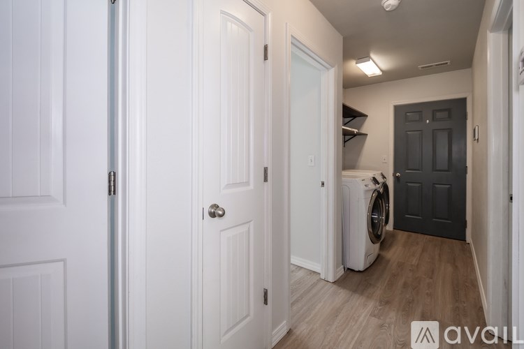 A hallway with a washing machine in the doorway.