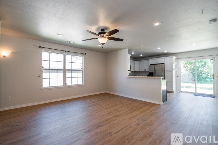 A spacious living room with a ceiling fan and sliding glass doors.