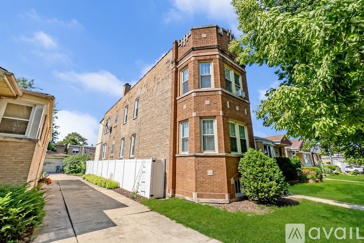 A brick building with a white fence in front of it.