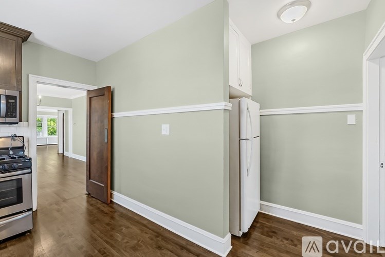 A kitchen with a stove, refrigerator, and cabinets.