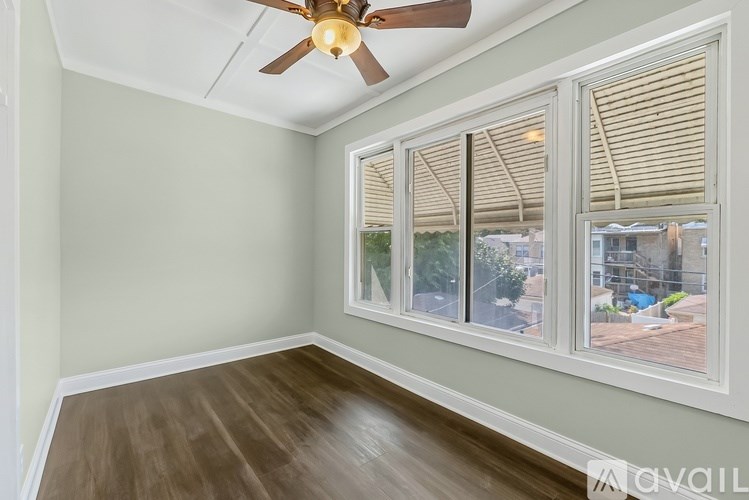A room with a ceiling fan and a window with blinds.
