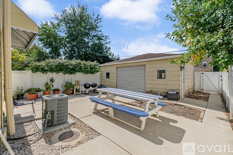A backyard with a bench, a fan, and a shed.