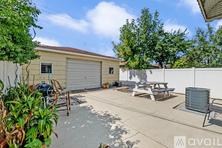 A backyard with a picnic table and a grill.