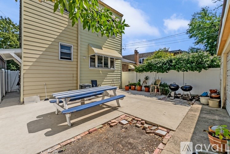 A backyard with a bench, a grill, and a small garden.