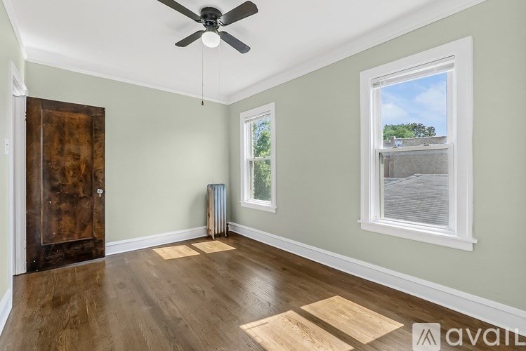A room with a ceiling fan, a window, and a door.