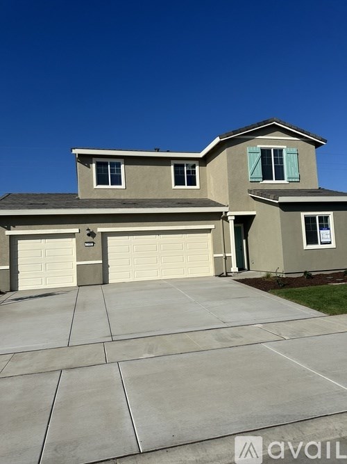 A two-story house with a garage and a driveway.