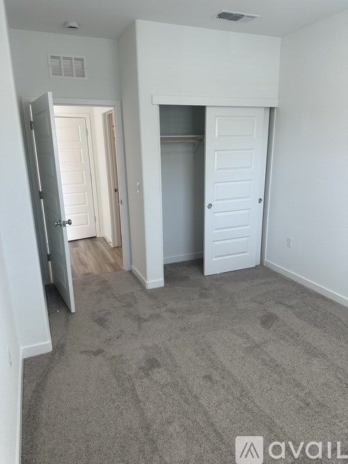 A room with a carpeted floor and a white door.
