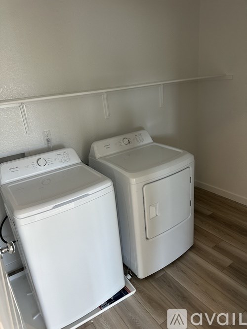 Two white front loading washing machines in a laundry room.