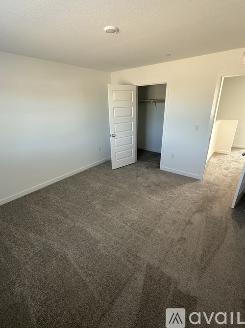 A room with a carpeted floor and a doorway leading to another room.