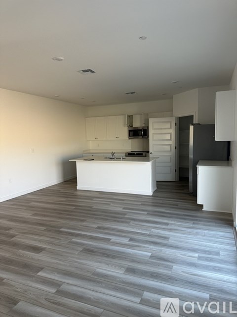 A kitchen with a white counter and cabinets with a grey floor.