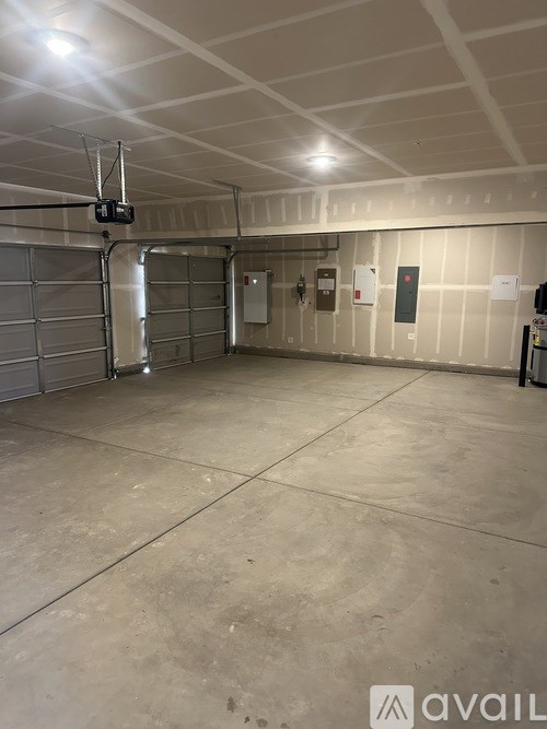 A large, empty garage with a concrete floor and white walls.