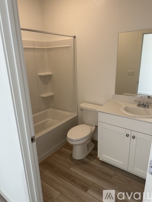 A white toilet sits in a small bathroom next to a sink and a bathtub.