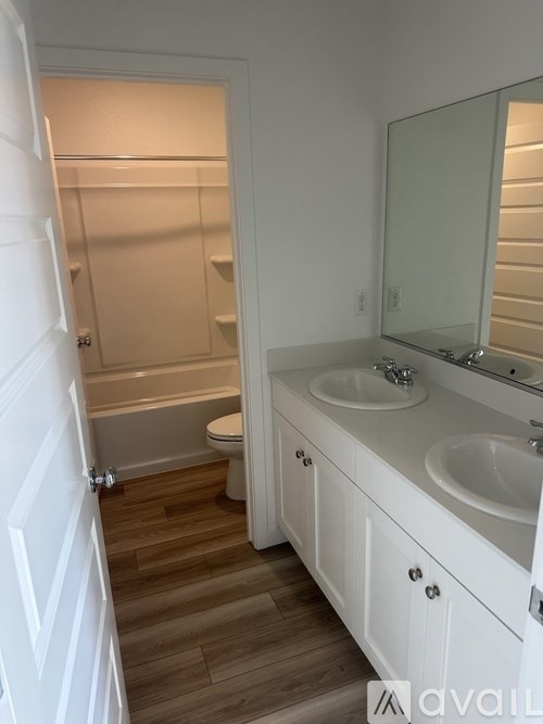 A bathroom with a toilet, sink, and mirror.
