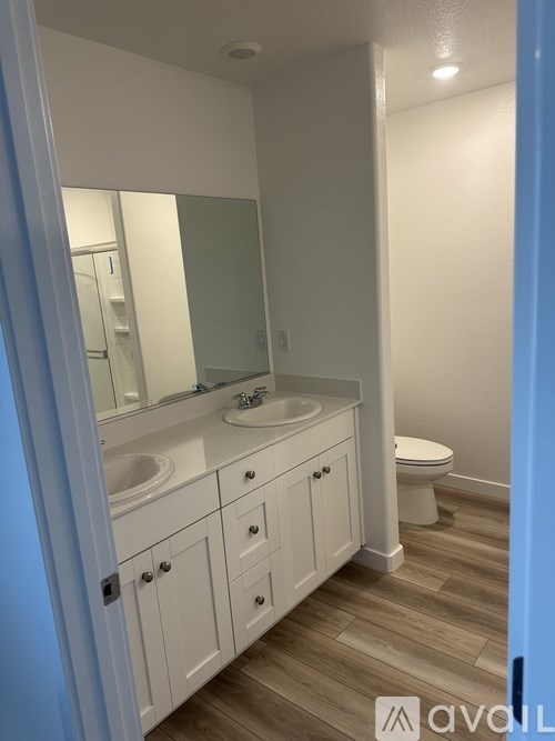 A bathroom with a white vanity and a white toilet.