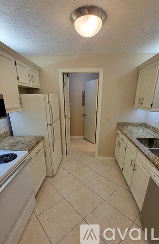 A kitchen with white cabinets and a tiled floor.