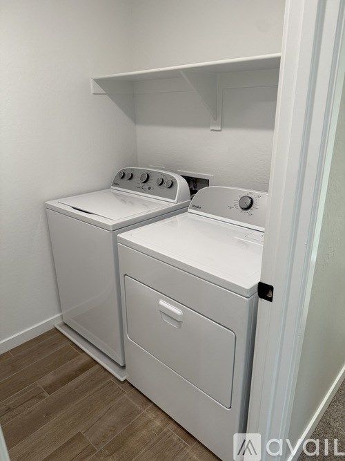 A white washing machine and dryer in a small laundry room.