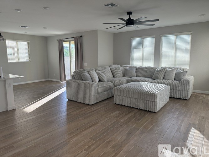 A living room with a grey sofa and ottoman.