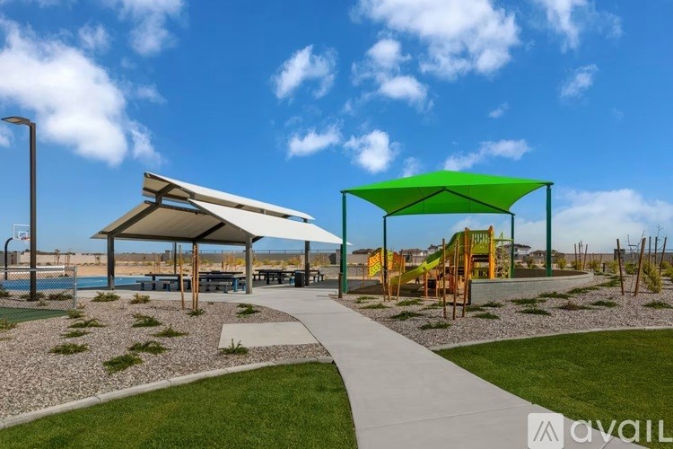 A park with a walkway, a green canopy, and a playground.