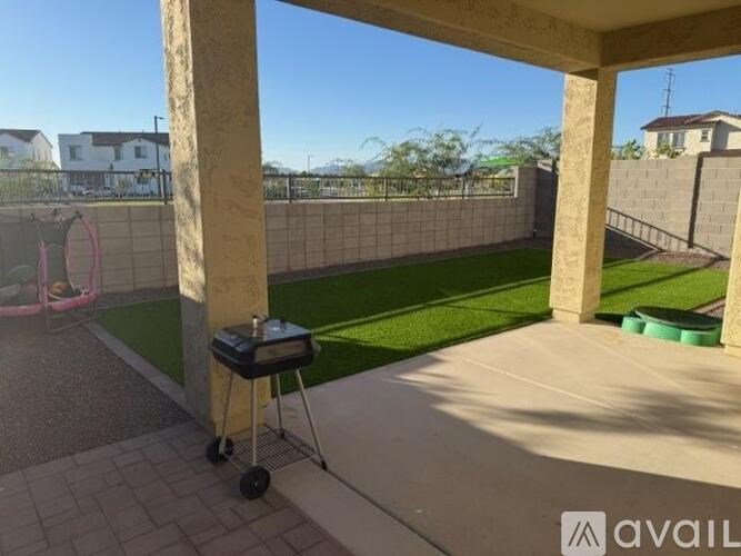 A patio with a barbecue grill and a green container on the floor.