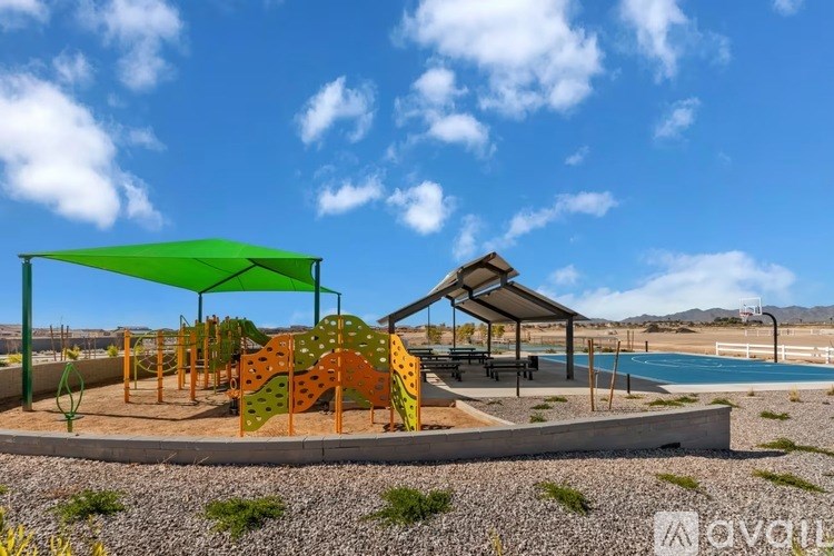 A playground with a green canopy and a slide.