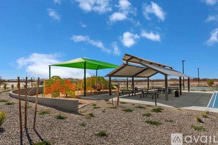 A playground with a green canopy and a slide.
