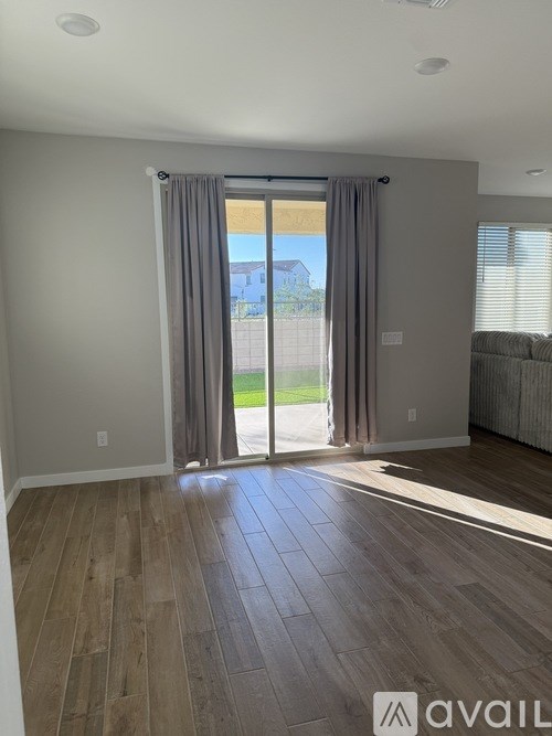 A room with a sliding glass door leading to a balcony.