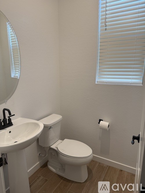 A white toilet and sink in a bathroom.