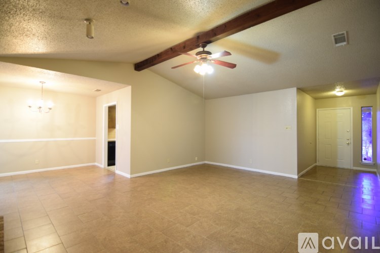 A spacious room with a ceiling fan and tiled flooring.