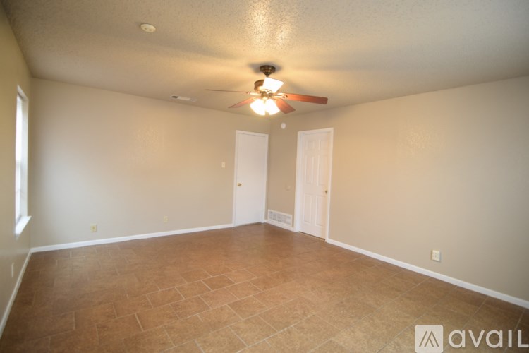 A room with a ceiling fan and tile flooring.