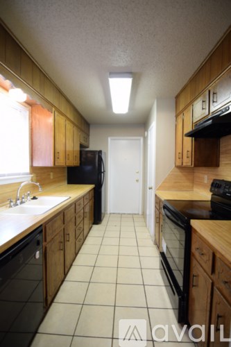 A kitchen with wooden cabinets and black appliances.