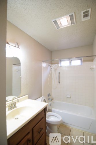 A bathroom with a toilet, sink, and bathtub.