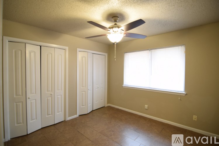 A room with a ceiling fan and a window.